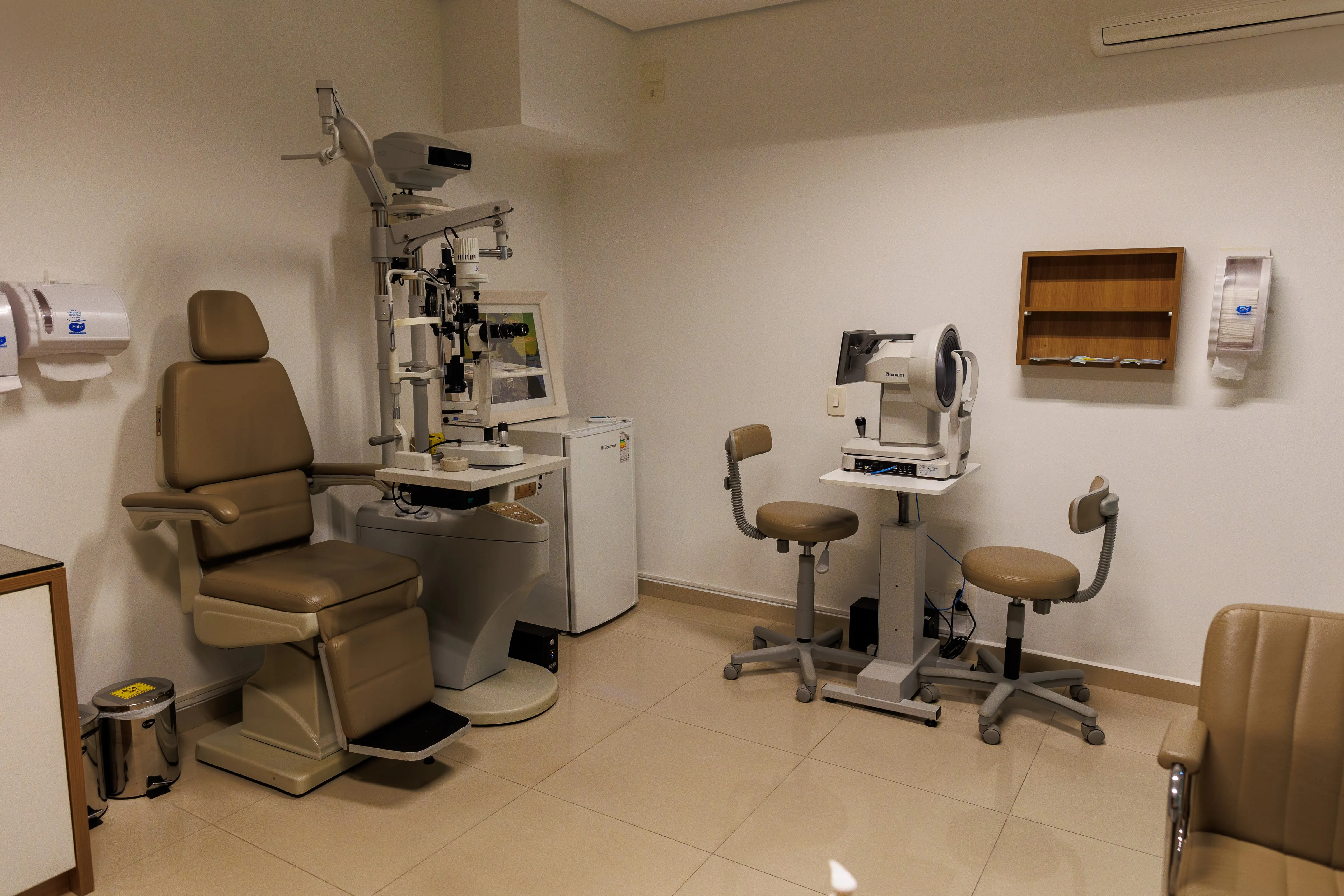 Consultório oftalmológico com cadeira de exames e equipamentos médicos